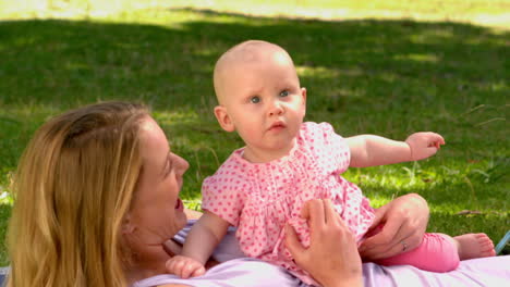 Mother-lying-with-her-baby-girl-in-the-park