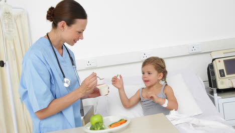 Nurse-feeding-sick-little-girl-in-bed