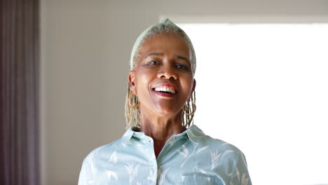African-American-senior-woman-standing-indoors,-smiling-at-camera