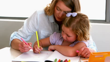 Mother-colouring-with-daughter-at-kitchen-table