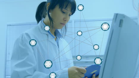 Animation-of-network-of-medical-icons-over-asian-female-scientist-working-at-laboratory-computer