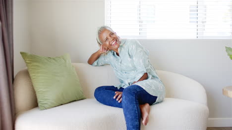 Afroamerikanische-Seniorin-Sitzt-Auf-Der-Couch-Und-Lächelt-In-Die-Kamera