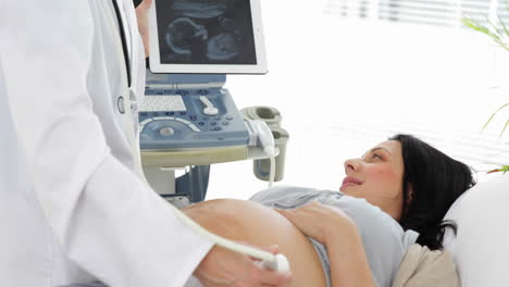 Brunette-pregnant-woman-having-a-sonogram-scan