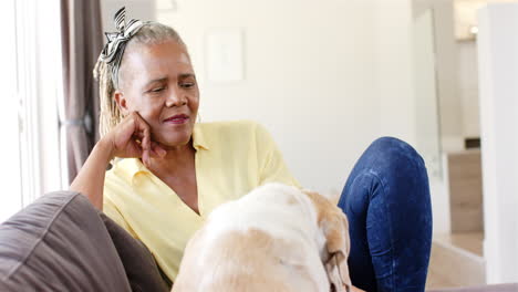 A-senior-African-American-woman-with-grey-hair-is-relaxing-with-her-dog