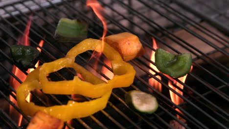 Vegetables-falling-onto-flaming-barbecue