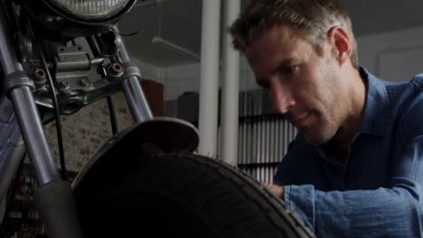 Front-view-of-Caucasian-male-mechanic-repairing-motorbike-in-repair-garage-4k