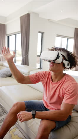 Vertical-video:-A-young-biracial-man-is-engaged-with-virtual-reality