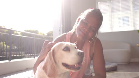 A-senior-African-American-woman-is-petting-her-dog-at-home