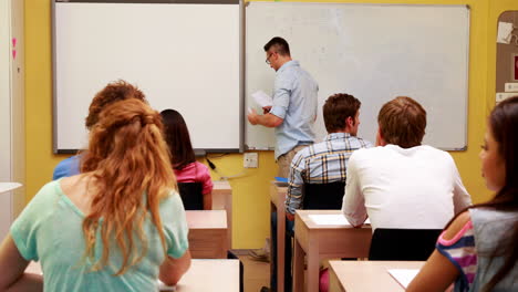 Profesor-Escribiendo-En-La-Pizarra-En-Clase