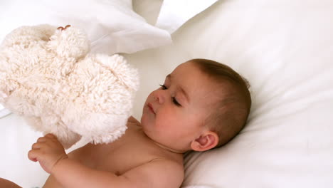 Cute-baby-on-a-bed-with-teddy-bear