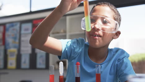 In-school,-a-young-African-American-student-examines-a-test-tube-in-the-classroom