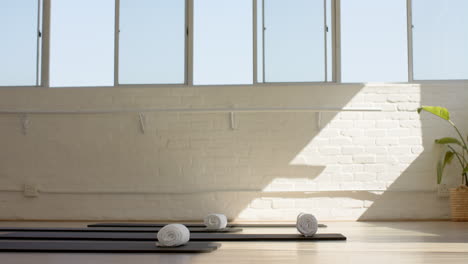 A-yoga-mat-and-towels-are-ready-for-class-in-a-bright-studio