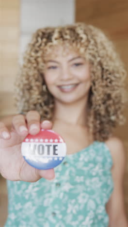 Vídeo-Vertical:-Joven-Birracial-Sosteniendo-Una-Credencial-De-Voto,-Sonriendo