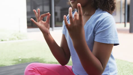 Chica-Birracial-Medita-Al-Aire-Libre,-Tocándose-Los-Dedos-En-Una-Pose-Mudra