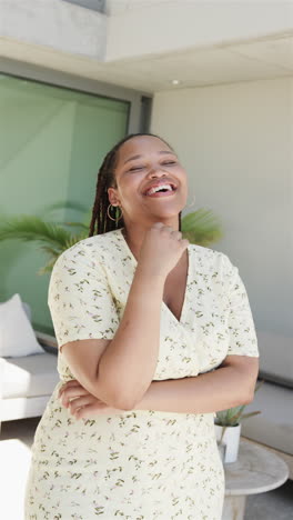 Vertical-video:-Biracial-woman-laughing,-standing-outside