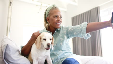 African-American-senior-woman-taking-selfie-with-dog-at-home