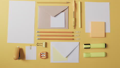 Assorted-stationery-items-are-neatly-arranged-on-a-yellow-background