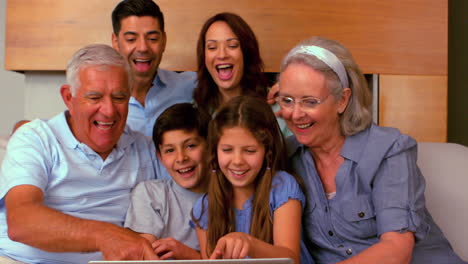 Extended-family-using-laptop-together-on-couch