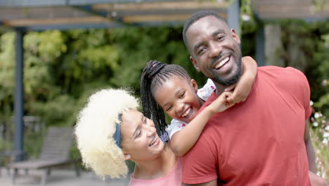 Un-Hombre-Afroamericano-Y-Una-Mujer-Birracial-Se-Ríen-Con-Una-Chica-Alegre-Al-Aire-Libre