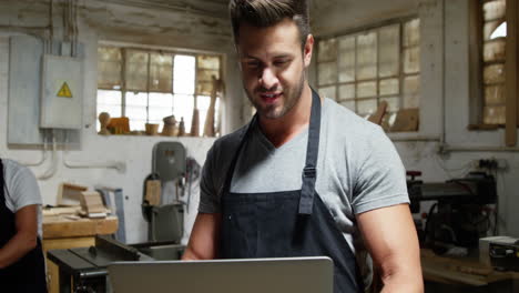 Two-carpenters-looking-at-laptop-while-working