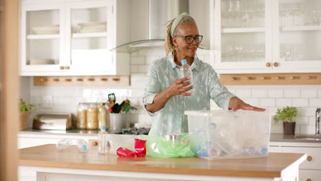 A-senior-African-American-woman-sorting-recycling-in-kitchen