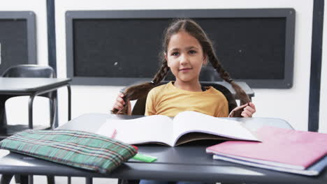 En-Un-Ambiente-Escolar,-Un-Joven-Estudiante-Caucásico-Se-Sienta-En-Un-Escritorio