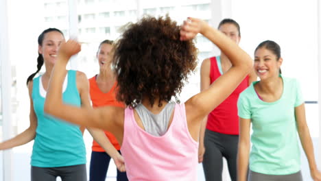 Pretty-instructor-leading-zumba-class-in-fitness-studio