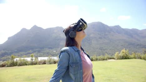 A-young-woman-wearing-virtual-reality-headset-standing-outdoors