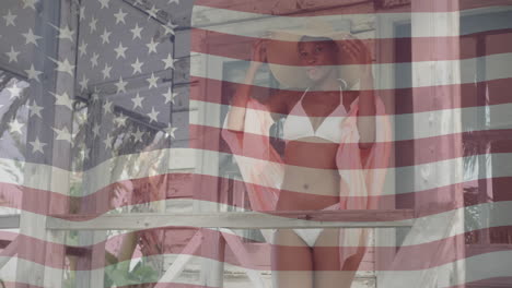 Animation-of-american-flag-over-happy-african-american-woman-wearing-hat-and-bikini-in-the-sun