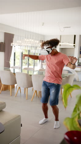 Vertical-video:-A-young-biracial-man-enjoys-VR-gaming-in-modern-home