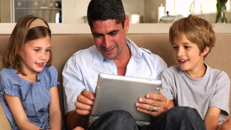 Niños-Lindos-Usando-Tablet-Pc-Con-Padre-En-El-Sofá
