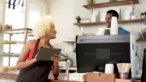 Un-Joven-Afroamericano-Y-Una-Mujer-Birracial-Usan-Una-Tableta-En-Una-Cafetería