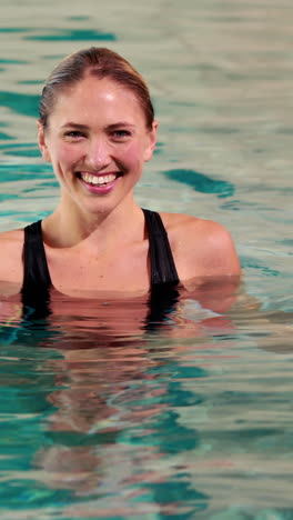 Fit-woman-doing-aqua-aerobics-in-the-pool-with-foam-dumbbells