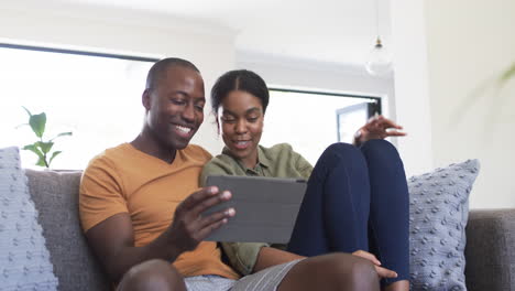 Ein-Junges-Afroamerikanisches-Paar-Genießt-Gemeinsam-Ein-Tablet-Zu-Hause-Auf-Der-Couch