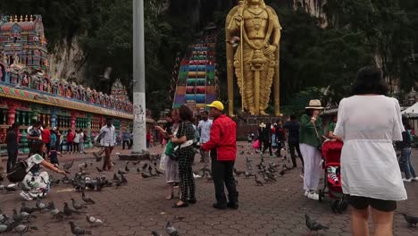 Touristen-Drängen-Sich-Inmitten-Einer-Schar-Tauben,-Die-Fotos-An-Der-Statue-Des-Batu-Höhlentempels-In-Kuala-Lumpur-Machen