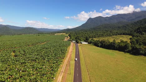4K-drone-video-following-a-camper-van-that-is-driving-through-the-lush-greenery-in-Tropical-North-Queensland,-Australia