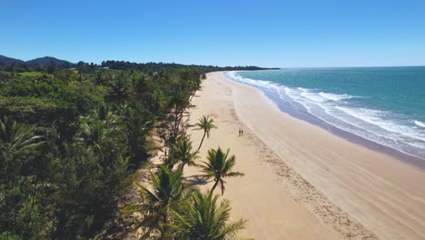 4K-Drone-Video-of-a-couple-walking-along-the-iconic-Mission-Beach,-Queensland-Australia