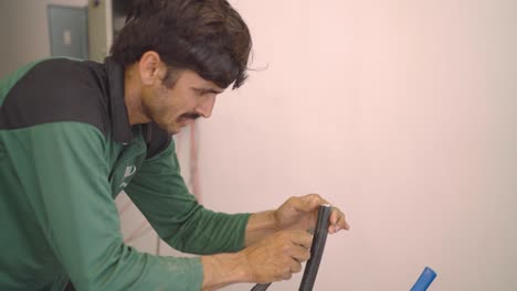 Electricista-Paquistaní-Cortando-Alambre-Con-Cuchillo