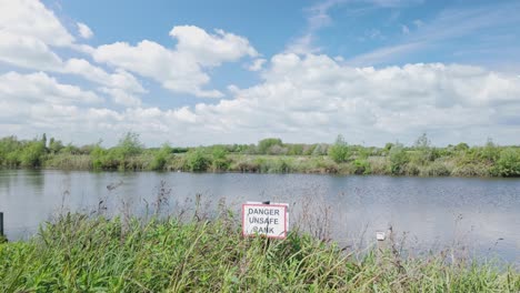 Danger-Unsafe-Bank,-safety-precaution-sign-on-River-Waveney