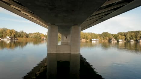 Un-Dron-Captura-Un-Tranquilo-Río-Europeo-Y-Revela-La-Parte-Inferior-De-Un-Puente.