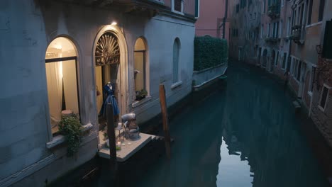 Venezianische-Kanalszene-Mit-Stilvoller-Fassade,-In-Der-Elegante-Kleider-Ausgestellt-Sind,-Italien