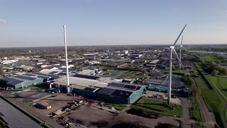 Schwenken-Sie-Die-Enthüllung-Von-Windturbinen-Mit-Sauberer-Energie,-Sonnenkollektoren-Und-Einem-Zentrum-Für-Wasserreinigungsanlagen-In-Der-Niederländischen-Agrarlandschaft-Von-Oben-Aus