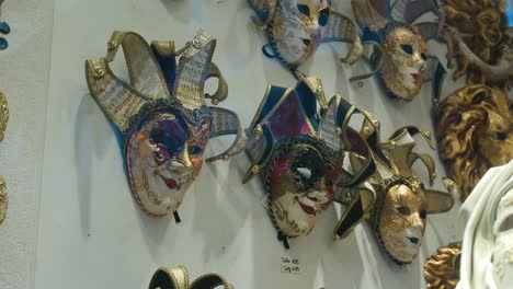 Colorful-Venetian-carnival-masks-with-intricate-designs-displayed-on-a-white-wall