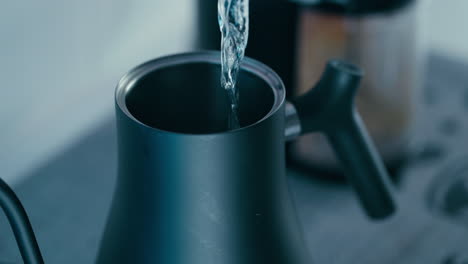 Pouring-water-from-Filter-into-the-black-Barista-Water-Kettle-in-slow-motion