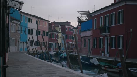 Charmante-Kanalszene-Auf-Der-Insel-Burano,-Venedig,-Mit-Bunten-Häusern-Und-Booten,-Die-Entlang-Des-Kanals-Vertäut-Sind