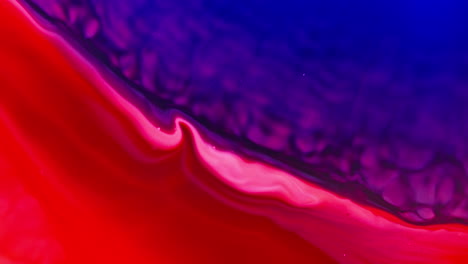 Vibrant-red-and-purple-ink-swirling-and-mixing-in-water,-creating-abstract-patterns