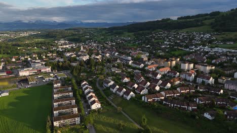 Suburb-neighborhood-area-with-green-meadows-during-golden-hour,-Switzerland
