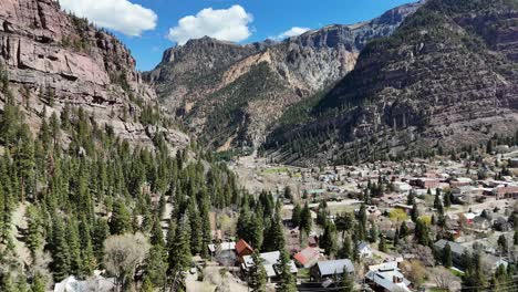 Einspielung-Einer-Kleinen-Stadt-Umgeben-Von-Pinien-Und-Bergen,-Blauer-Himmel-Mit-Wolken-Im-Spätfrühling,-Ouray-Colorado