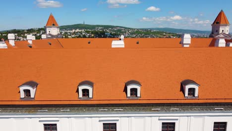 Cinematic-Aerial-View-of-Skyline-of-Bratislava,-Slovakia-on-a-Warm,-Sunny-Summer-Day-with-Beautiful-Mountains-in-the-Background