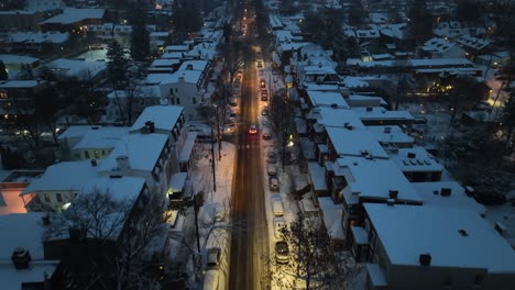 Snowy-evening-in-a-residential-neighborhood-with-glowing-streetlights-and-snow-covered-roofs,-creating-a-serene-winter-scene
